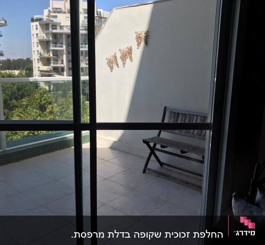 דלת זכוכית עם מסגרת מתכת במרפסת